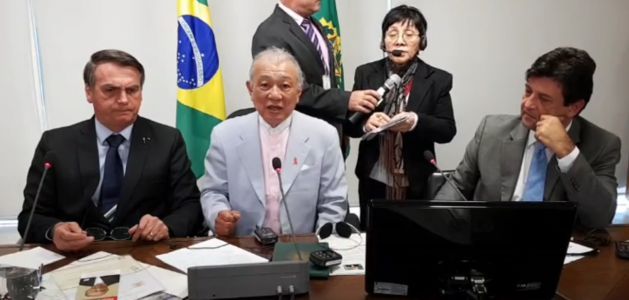 The president of the Nippon Foundation, Yohei Sasakawa (C) is seen meeting with the president of Brazil, Jair Bolsonaro (L), in an IPS screen capture from the video that the president broadcast on Facebook to raise public awareness about the importance of eliminating Hansen's Disease, better known as leprosy, and eradicating the prejudice faced by patients and their families. Credit: IPS
