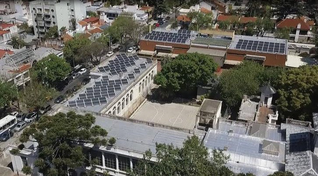 Aerial view of the rooftops of the primary and secondary schools located across from the main square in Villa Devoto, a residential neighborhood in the Argentine capital. The adjacent schools now have 200 solar panels with an installed capacity of 70 kilowatts, and the surplus is injected into the Buenos Aires electricity grid. Credit: Courtesy of Buenos Aires city government