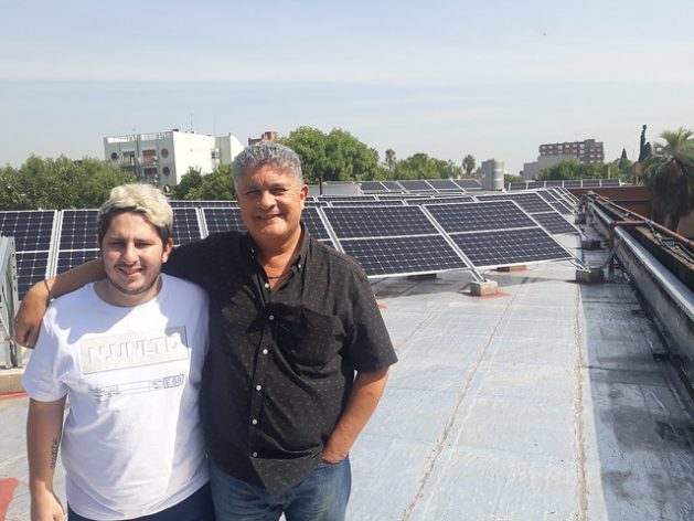 Sebastián Ieraci (L), a member of the group of students who in 2014 pushed for the switch to solar energy at the Antonio Devoto High School, stands next to the school's principal Marcelo Mazzeo on the rooftop of the educational institution located in the Buenos Aires neighbourhood of Villa Devoto. Credit: Daniel Gutman/IPS