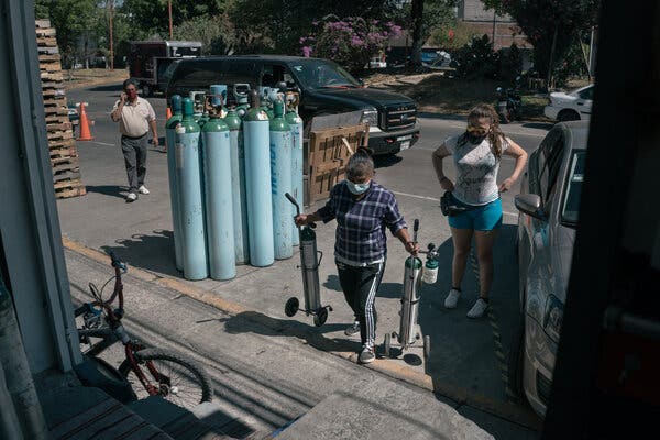 An employee carries oxygen tanks to refill them at an uncertified private oxygen provider in Mexico City this month. In Mexico, hospitals have been so overrun that virus patients have been dying in their homes, gasping for air because there are not enough oxygen tanks to meet the need. As many as 20 poor countries were in urgent need of oxygen.