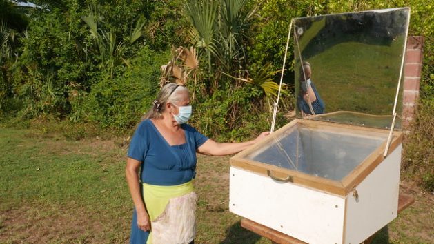 María Luz Rodríguez stands next to her solar oven where she cooked lasagna in the village of El Salamar in San Luis La Herradura municipality. In this region in southern El Salvador, an effort is being made to implement environmental actions to ensure the sustainable use of natural resources. CREDIT: Edgardo Ayala/ IPS