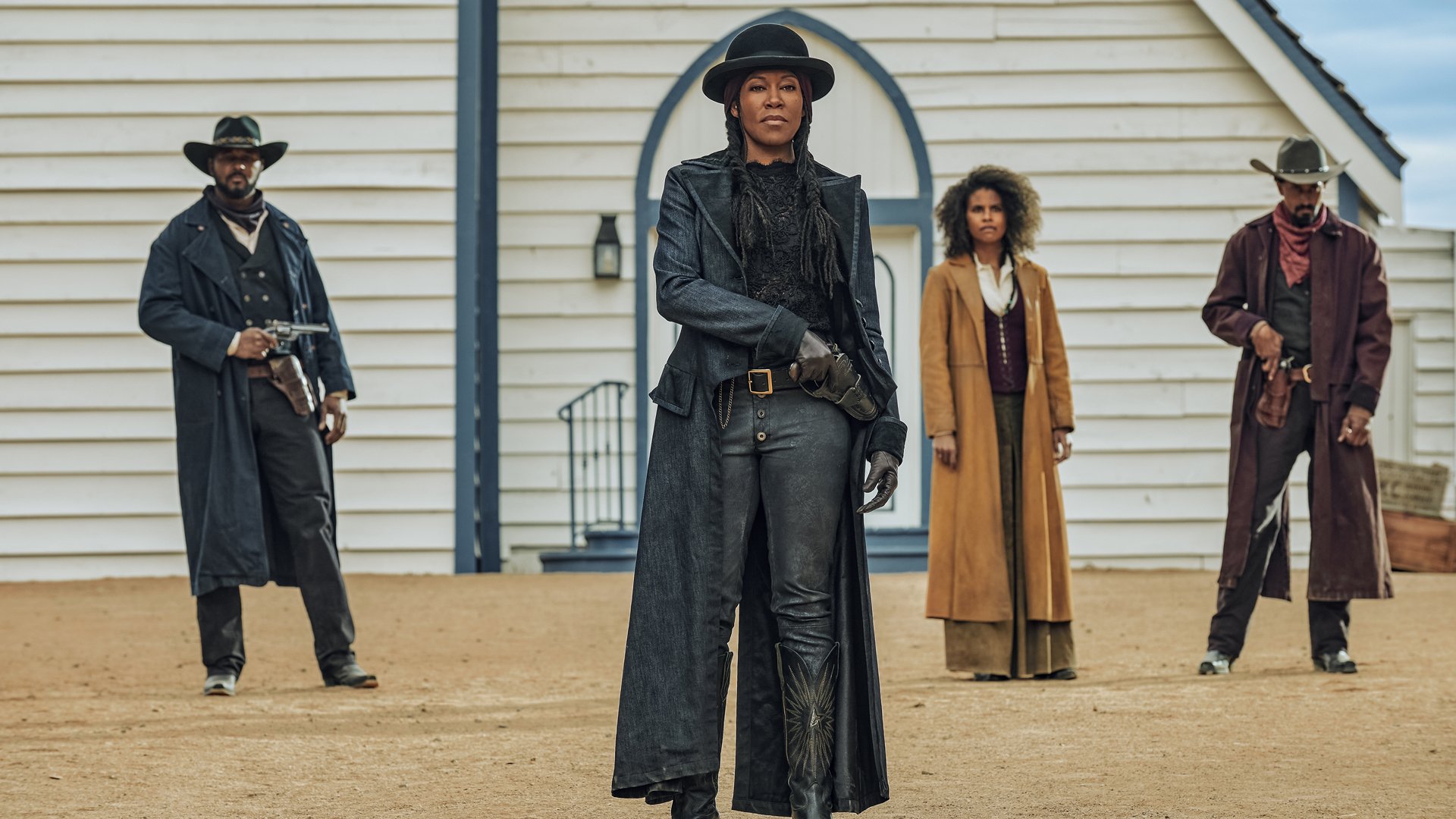 J.T. Holt, Regina King, Zazie Beetz, and Justin Clarke stand in a Western set in costume.