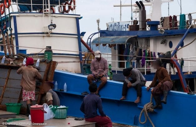 Workers take a break after unloading fish from the Sor Somboon 19 fishing vessel. Initial screenings conducted by Greenpeace revealed that the crew of this Thai trawler met internationally accepted definitions of forced labour. Credit: Greenpeace