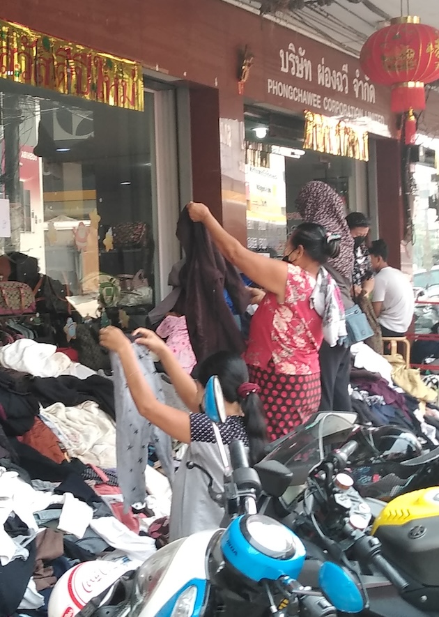 Myanmar refugees in Thailand pick out clothes piled in the street that have been donated in the border town of Mae Sot. Credit: William Webb/IPS 