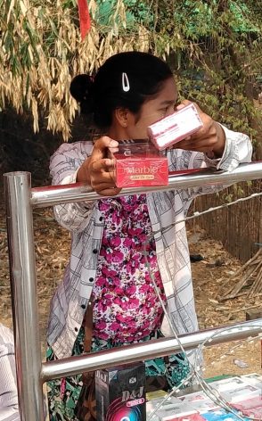 A Myanmar girl, displaced by war, sells cigarettes through the razor-wired border with Thailand near the frontier town of Mae Sot. Thailand is bracing for another influx of refugees. Credit: William Webb/lPS