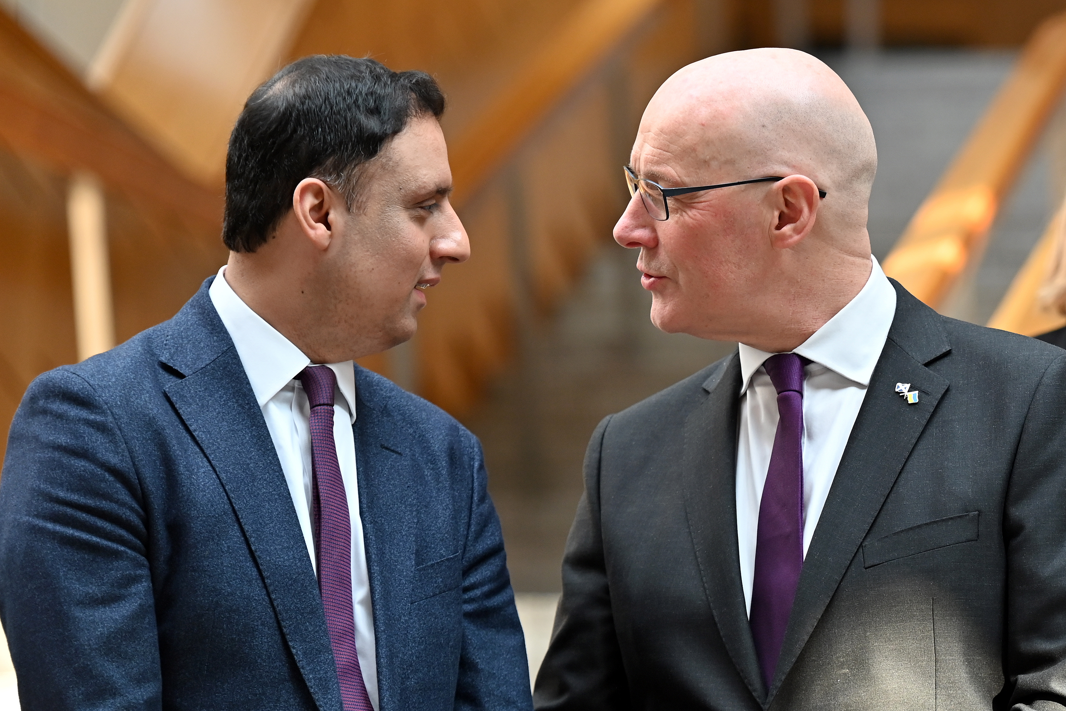 Scottish First Minister John Swinney chats with Scottish Labour leader Anas Sarwar in the Scottish Parliament lobby.