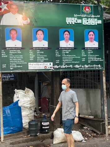 A man walks past a campaign poster for the military’s proxy party USDP ahead of strictly controlled elections in Myanmar. Credit: Guy Dinmore/IPS