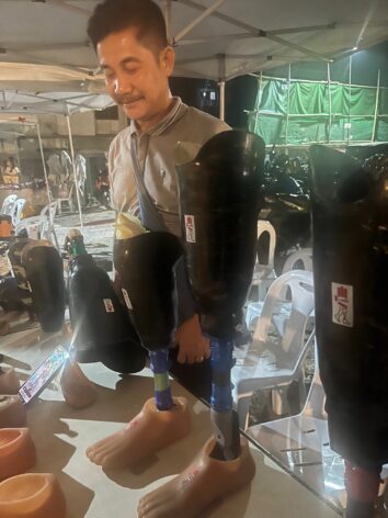 Prosthetics marketed by I-Walk at an event marking resistance to Myanmar’s military coup of five years ago. The enterprise has a waiting list of over 3,000 people. Credit: Guy Dinmore/IPS